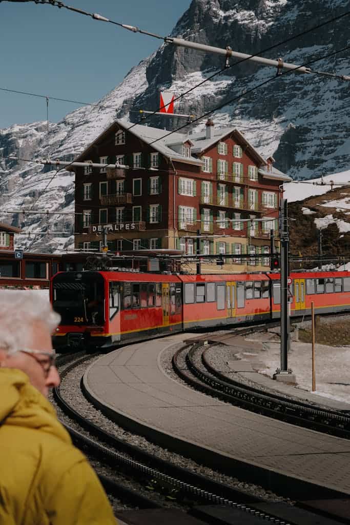 Tram Riding in front of a Hotel in a Mountain Valley in Switzerland